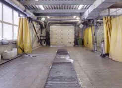Interior view of a modular wash bay installation with yellow curtains and cleaning equipment.