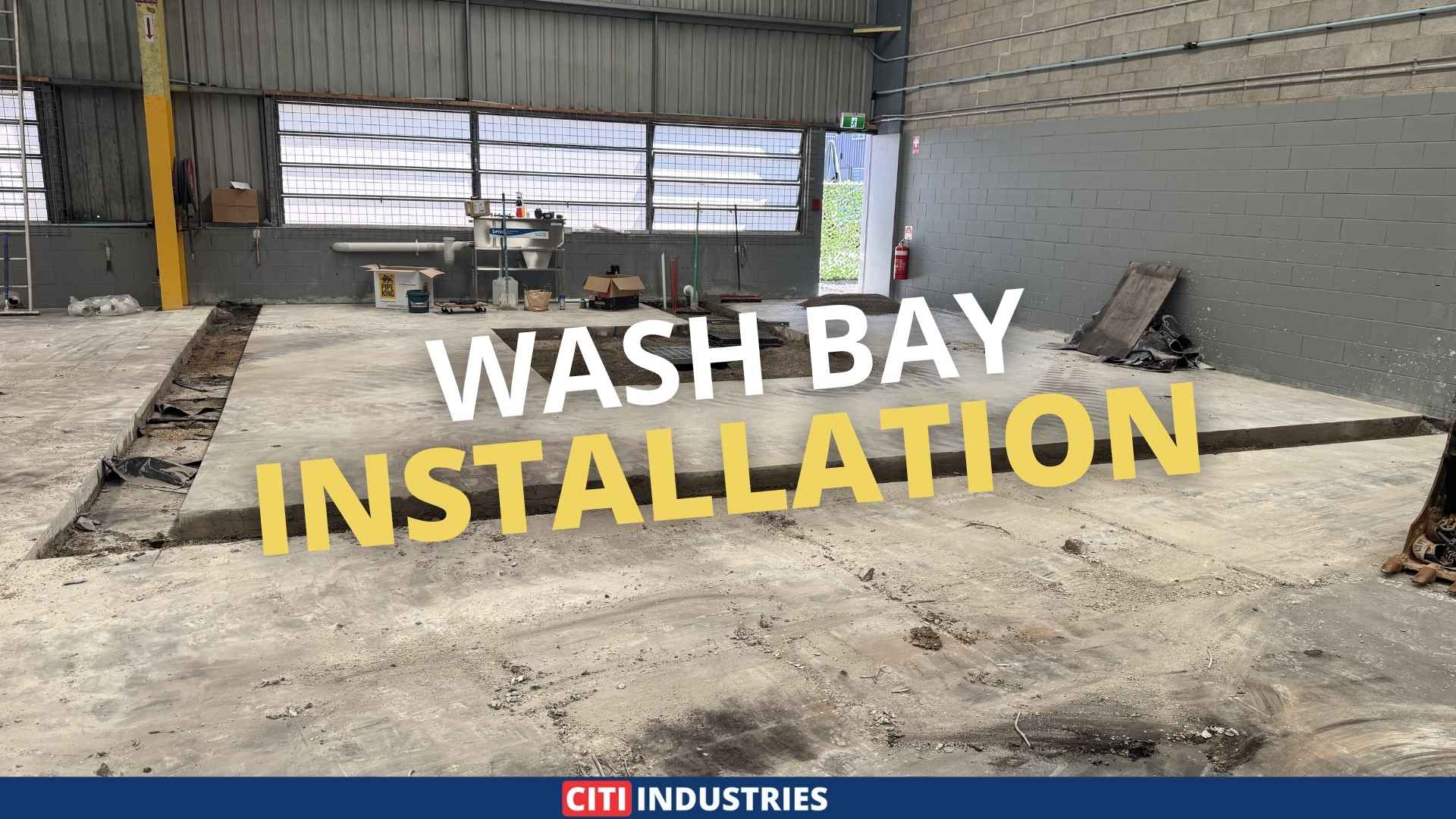 Commercial wash bay installation in progress showing concrete slab preparation and drainage infrastructure for automotive wash bay compliance at a Queensland industrial facility.